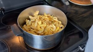 A pot filled with dried apple slices sits on a stovetop, ready to be cooked